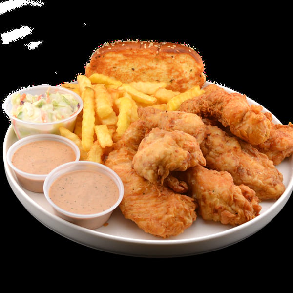 Crispy fried chicken tenders, golden fries, coleslaw, two dipping sauces, and garlic bread on a white plate.