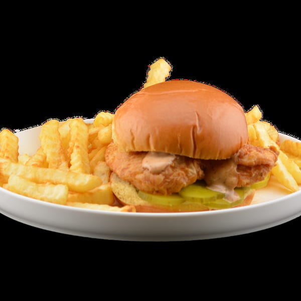 Crispy chicken sandwich with pickles and sauce on a bun, served with crinkle-cut fries.
